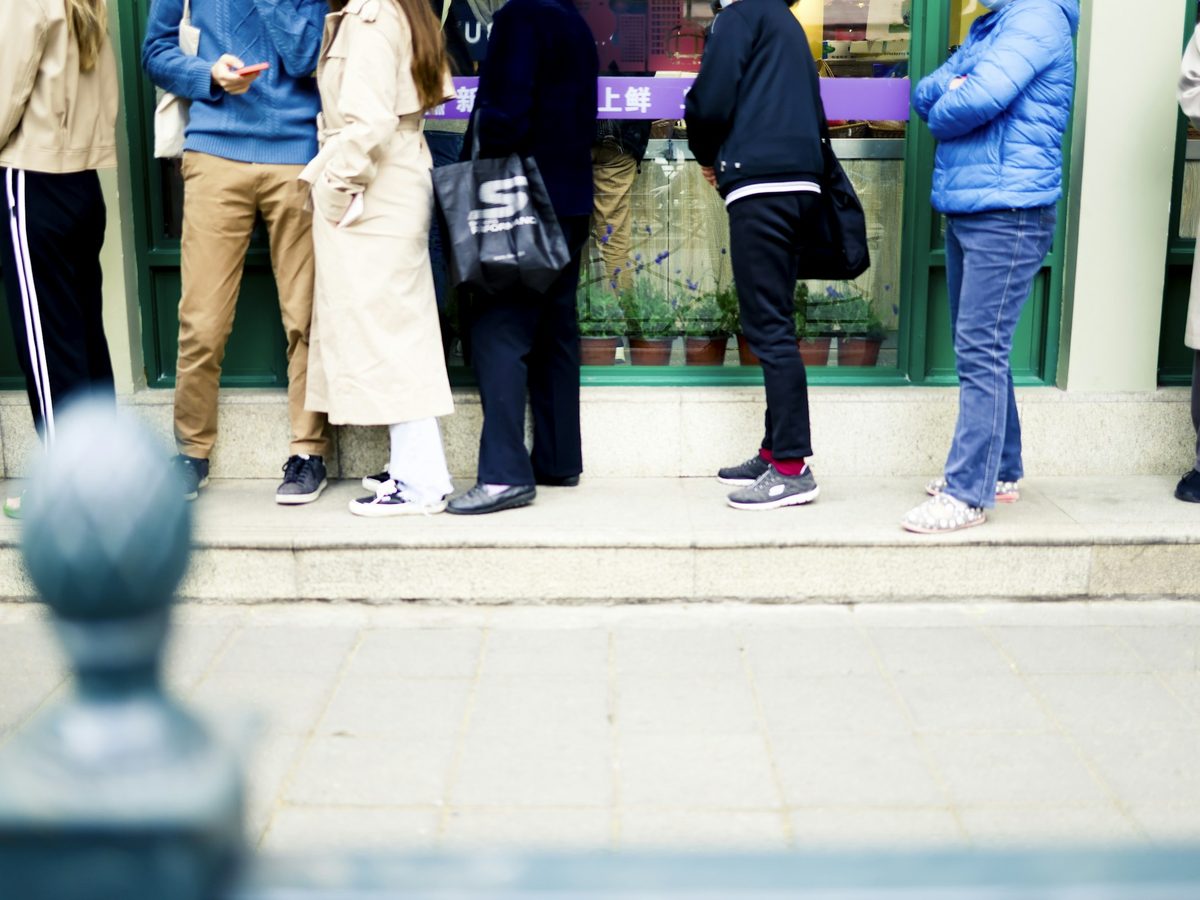 2. Lower bodies of people standing in a queue. Graphic, zero faces.