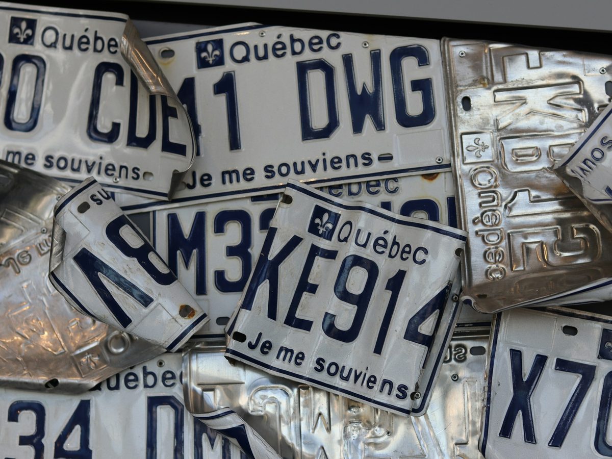 7. A pile of real Québec plates, 'Je me souviens' visible.