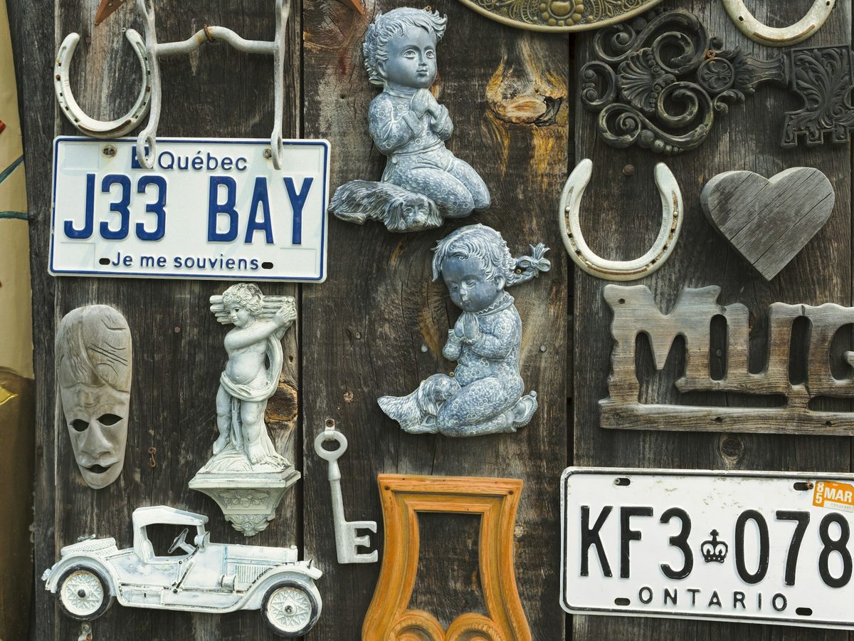 8. Rustic door hung with plates. A Québec 'J33 BAY / Je me souviens' plate front and centre.