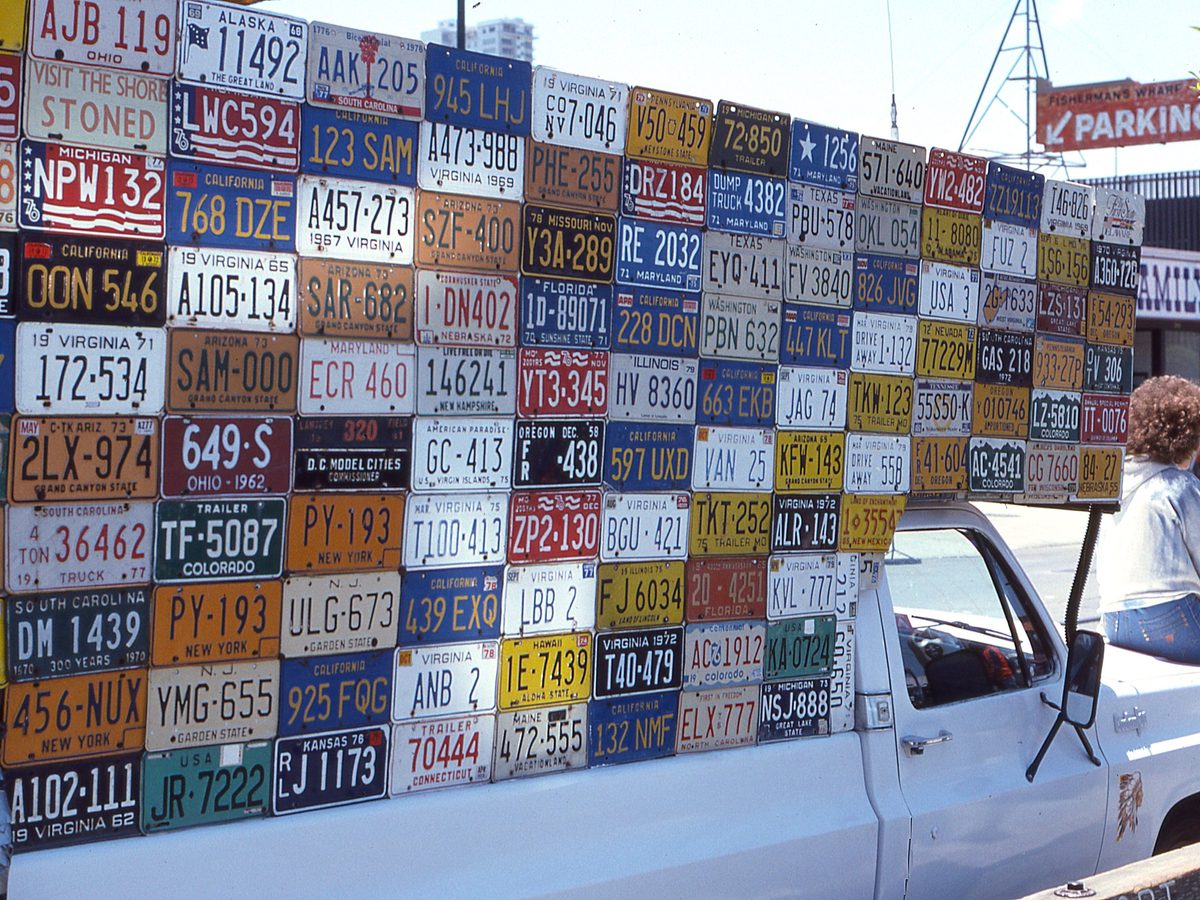 10. A whole fence tiled with licence plates. Big, dense, colourful texture.